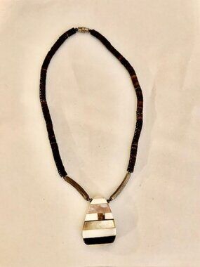 A southwestern style necklace with a pendant of mixed materials, unbranded.